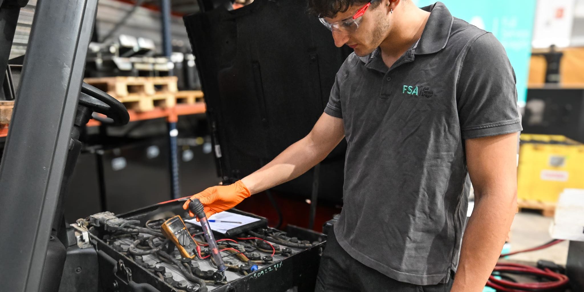 Técnico de FSA diagnosticando una batería de carretilla para reparar